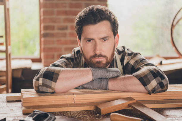 istock Portrait of handsome bearded master man restoration engineer folded hands sitting at his garage working with wooden constructions 2171311463