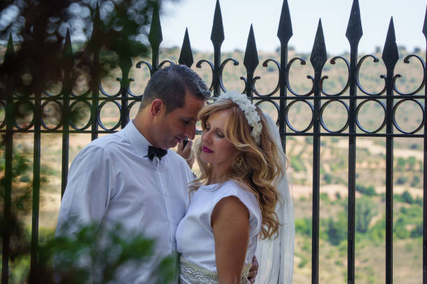 istock Bride and groom embracing near iron gate 2171313045