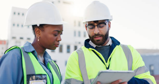 istock Business people, civil engineer and planning with tablet for architecture or construction on rooftop in city. Contractors, colleagues or architects with technology for building maintenance in town 2171314762
