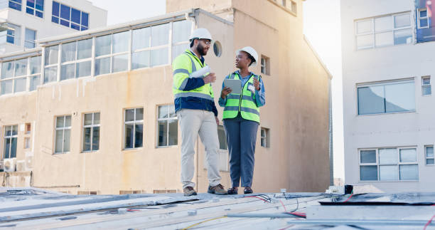 istock Business people, technician and discussion with tablet on rooftop for building maintenance or installation in city. Contractor, electrical engineer or electricians with technology for roof inspection 2171314769