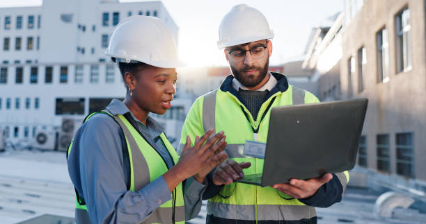 istock Laptop, discussion and construction team on rooftop site for city planning, renovation or building project. Computer, architecture and industrial civil engineers with maintenance check in town. 2171314793