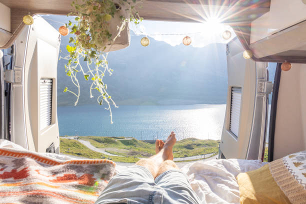 istock Man relaxing in camper van bed with lake and mountain view 2171315947