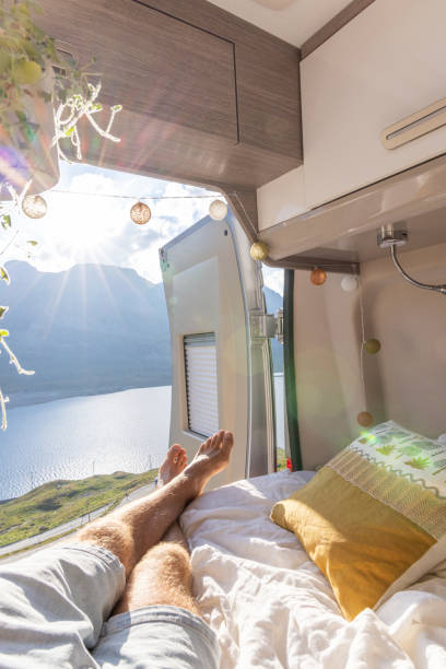 istock Man relaxing in camper van bed with lake and mountain view 2171316001