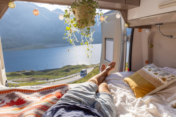 istock Man relaxing in camper van bed with lake and mountain view 2171316003