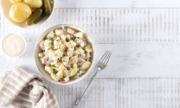 istock Potato salad with pickled cucumbers and onions. Top view on white background. Copy space. German, American cuisine. 2171316678