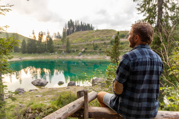 istock Man Enjoying a Serene View of a Mountain Lake 2171318942