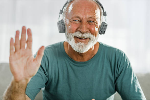 istock Happy senior man waving during a video call at home. 2171320245
