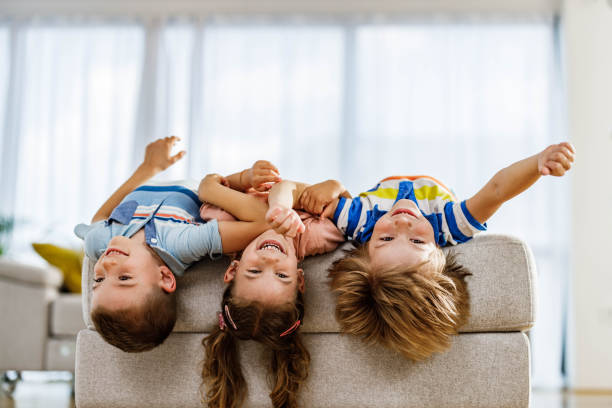 istock Carefree siblings having fun while lying on sofa at home. 2171320344