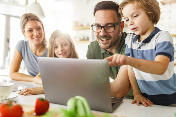 istock Happy family using laptop in the kitchen. 2171320367