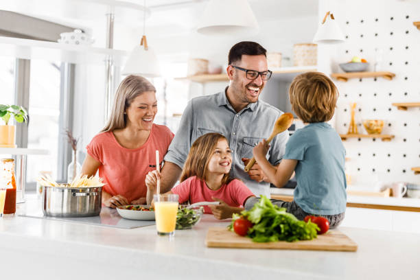istock Young happy family talking while preparing a meal in the kitchen. 2171320692