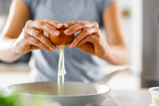 istock Close up of  a woman cracking an egg. 2171320782