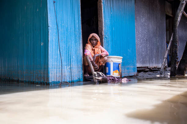 September 07, 2024, Noakhali, Chittagong,  Bangladesh: A woman sits in front of her flooded house in a village in Choumuhani Municipality of Noakhali District in Chittagong Division, Bangladesh.