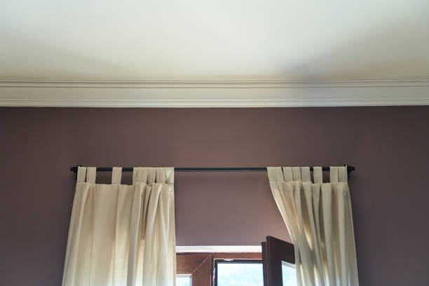 White ceiling and pink wall with part of an open window and light curtains. High quality photo