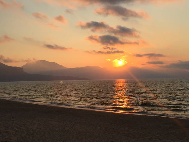 istock Sunset Over Ocean with Mountain Silhouettes 2171331032