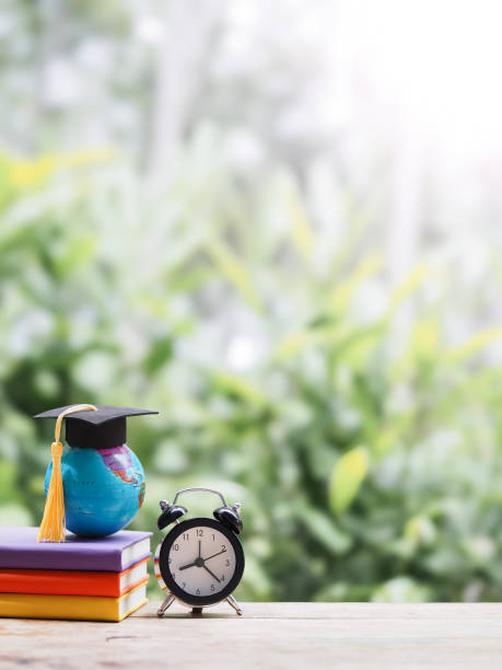 istock Student creative desktop , earth globe with graduation hat on hardcover book and black alarm clock. Copy space for text, Back to school, Education concept 2171331657