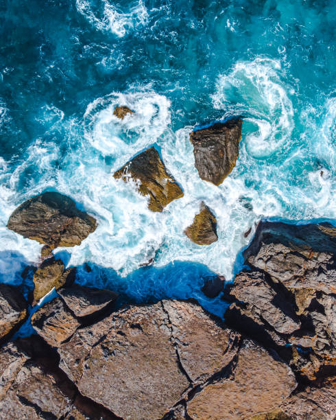 istock Waves crashing on a rough coastline, viewed from above with natural textures. 2171332813