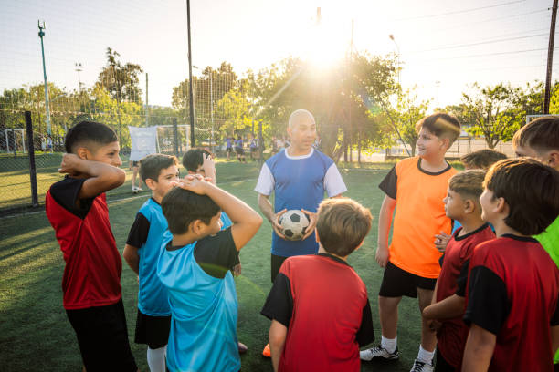 istock Kids and Coach on a Soccer Field 2171338726