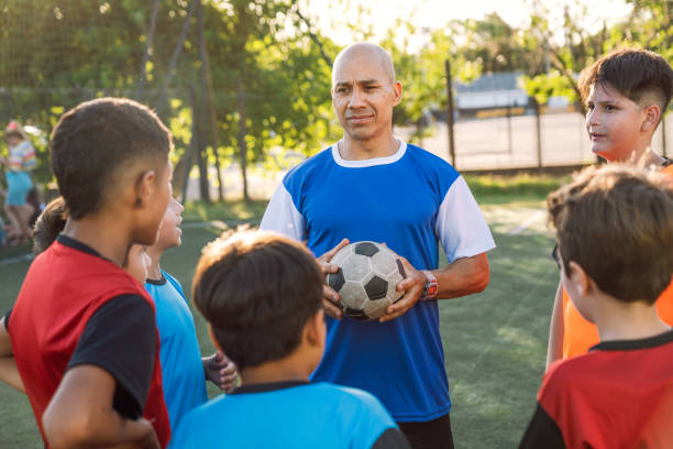 istock Kids and Coach on a Soccer Field 2171338817