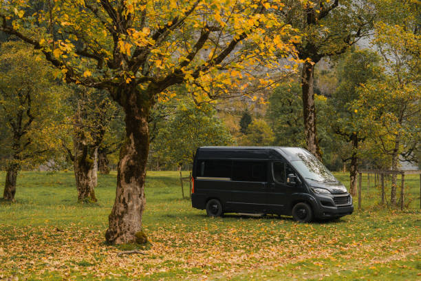 istock Camper van in autumn forest in Alps 2171338909