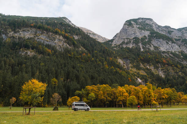 istock Camper van in autumn forest in Alps 2171339074