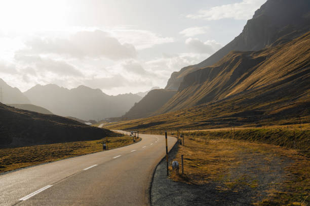 Scenic empty road through Alps in autumn at sunset