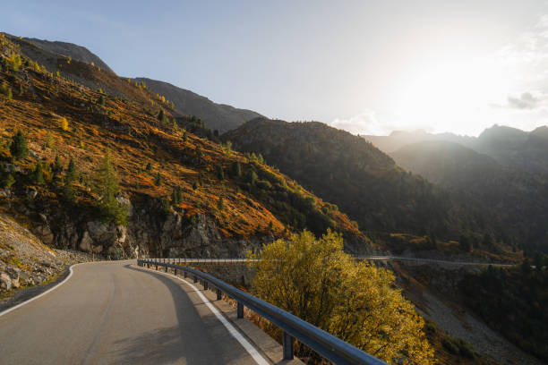 Scenic  view of empty road through European Alps in autumn at sunset