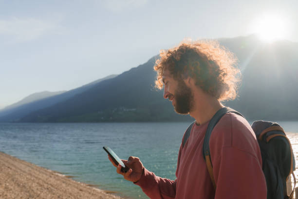 istock Man using smartphone hiking near the lake in autumn 2171339672