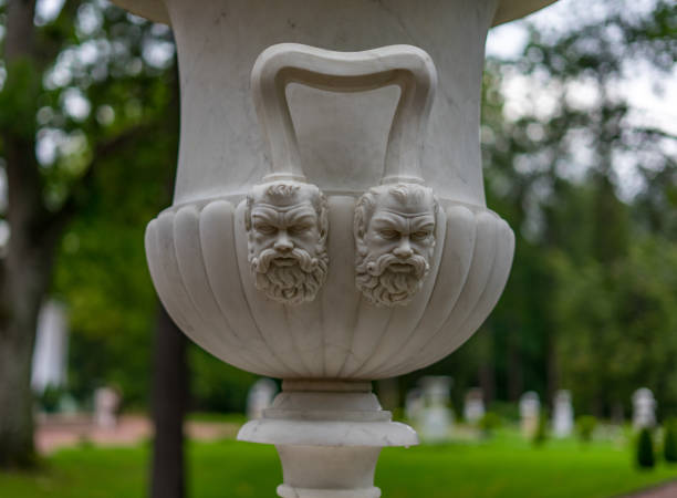 Russia, Lomonosov - August 31, 2024: Decorative element of two male faces on a marble vase in Oranienbaum Park