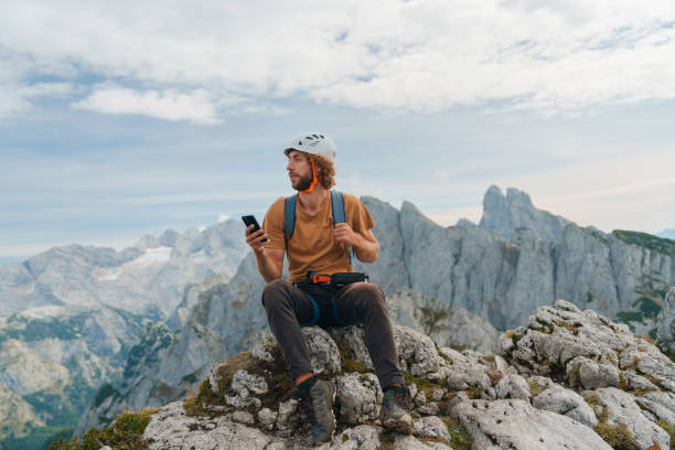 istock Man using smartphone on top of mountain after climbing 2171341590