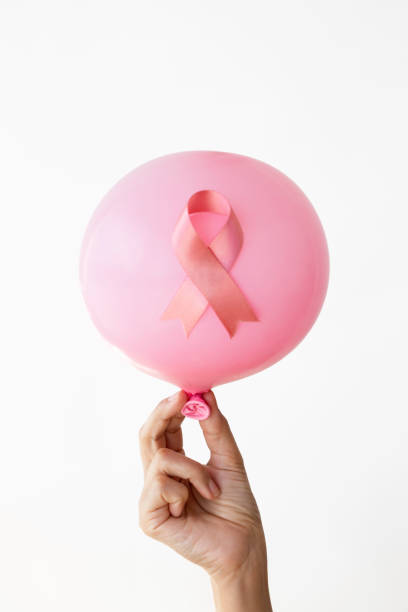 Hand holding pink balloon and pink ribbon.