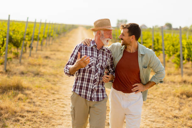 istock Two men stroll through a sunlit vineyard, sharing laughter and stories on a warm afternoon, surrounded by lush green vines 2171343927