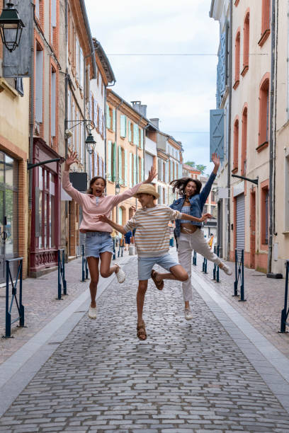 istock Happy Siblings Jumping on a Colourful Street 2171344031