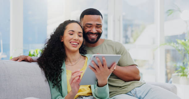istock Sofa, couple and laughing with tablet for comedy, streaming online and comfortable with connection at home. Happy people, man and woman with digital for funny film, watch movie and bonding in house 2171347571