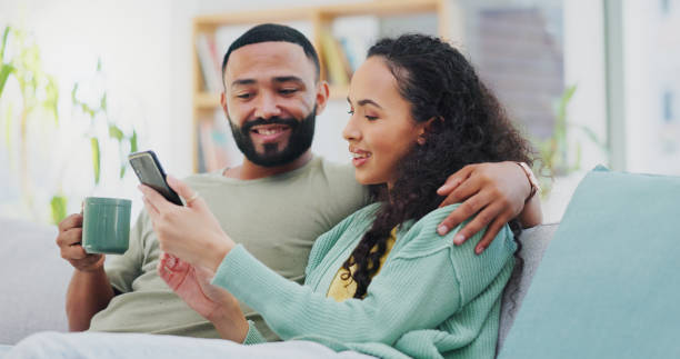 istock Home, cellphone and couple on sofa, connection and internet with coffee, relax and romance. Apartment, man and woman on couch, smartphone and social media with hug, comfort and herbal tea in lounge 2171347611