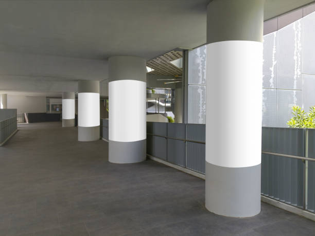 4 vertical blank poster templates on round pillars. Advertising pillar wrap mock ups along corridor walkway