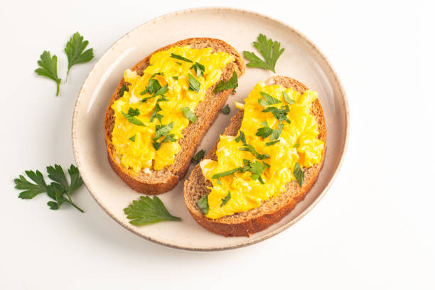 istock Scrambled eggs with green herbs on wheat-rye crispy toast. 2171351024