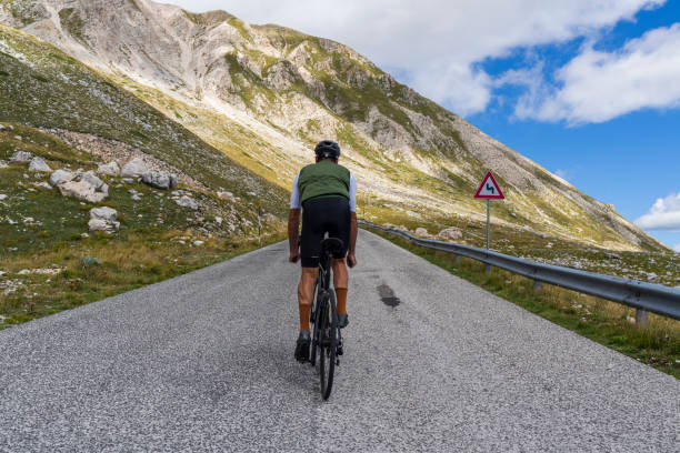 istock Cyclist climbing up mountain road 2171351072