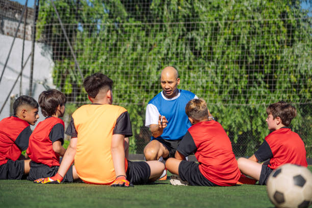 istock Soccer Coach Discussing Strategy with Young Team on Field 2171351417