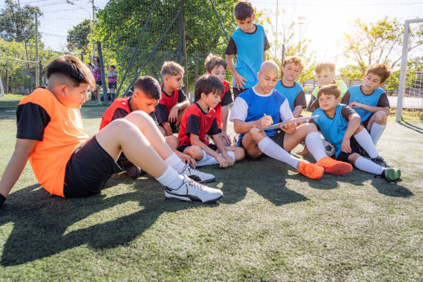 istock Soccer Coach Discussing Strategy with Young Team on Field 2171351505