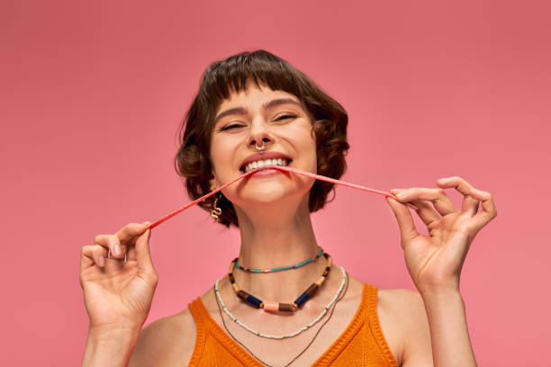 istock A young vibrant woman playfully poses with candy on a bright pink backdrop in the studio 2171352192