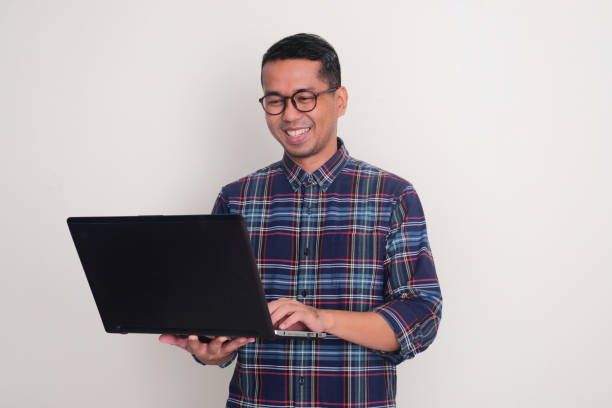 istock A man smiling happy when looking at laptop that he hold 2171352289