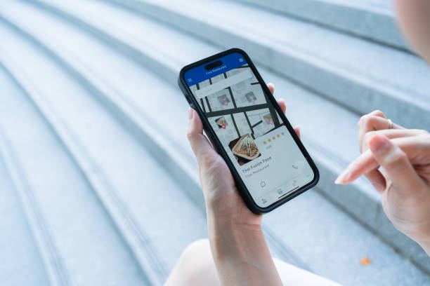 istock Person using mobile app to review restaurant on smartphone 2171353846