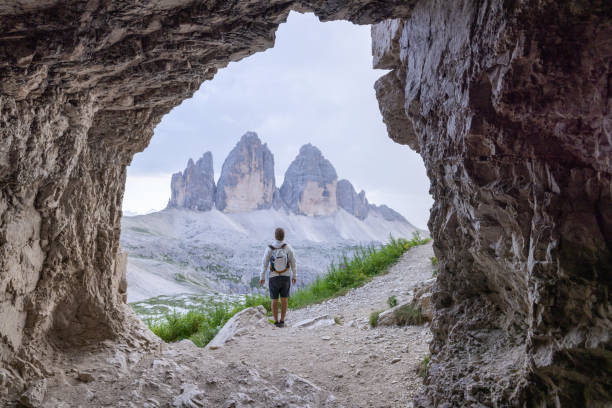 istock Hiker standing in cave, admiring mountain view 2171355358