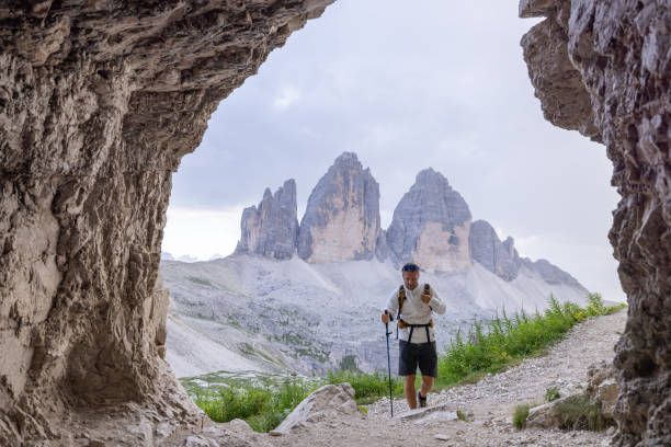 istock Hiker trekking through cave with mountain view 2171355790