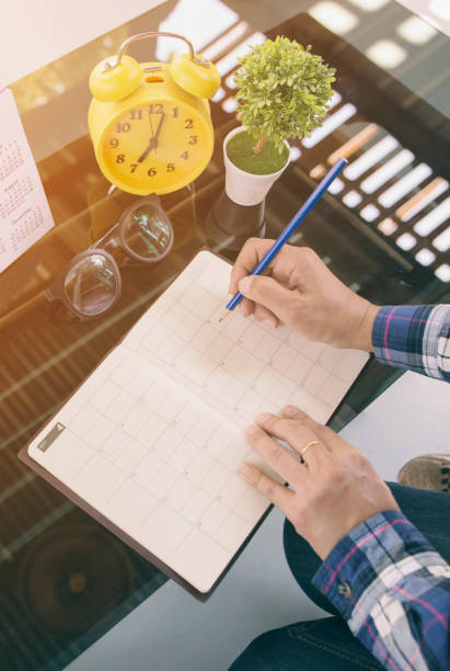 istock Calendar reminder event concept. Woman hand planner or organizer writing on diary book and 2019 Calendar page. Female planning appointment, noted and count Down schedule day on Calender-vertical image 2171355893