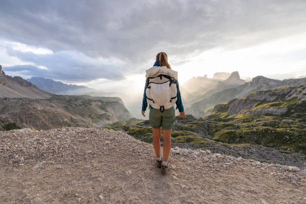 istock Woman hiking on mountain trail at sunrise with backpack 2171356254
