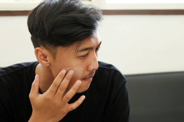 istock Asian Man Applying Moisturizer to His Face 2171356291