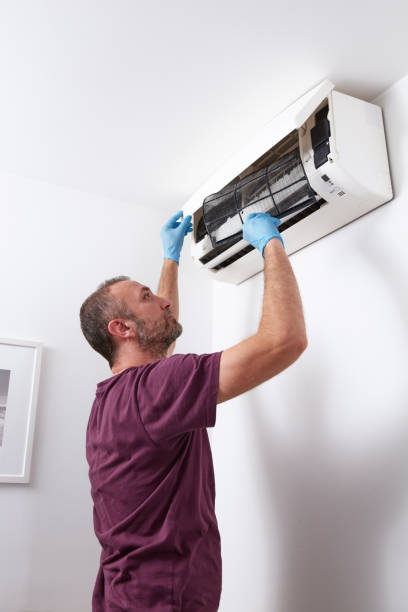 istock Man cleaning and maintaining air condition unit at home. 2171358473