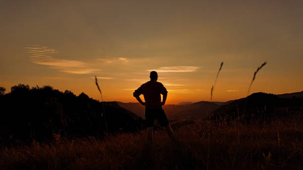 istock Silhouette of a man looking at the mountain sunset. 2171358499
