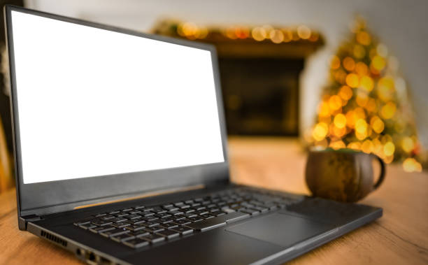 istock Laptop with a Blank White Screen and Christmas Tree in the Background 2171361513